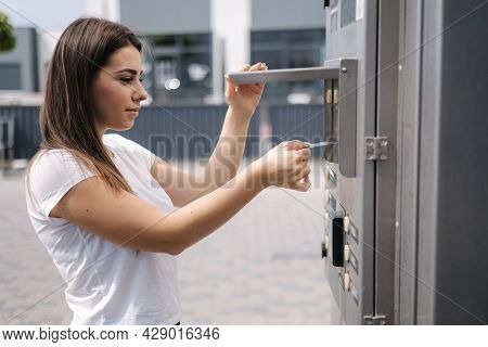 Woman Put Plactic Card For Paying Outdoors On Self-service Car Wash