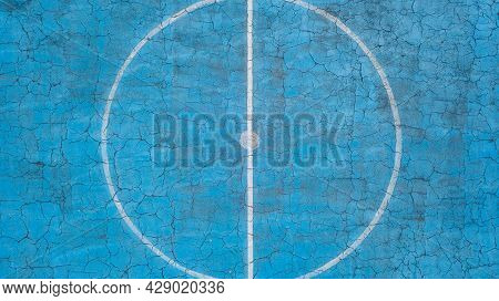 Multi-sport Court With A Central Circle And A Floor Painted Blue And Weathered
