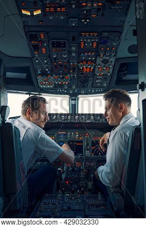Two Airmen Dressed In Uniforms Sitting In The Cockpit
