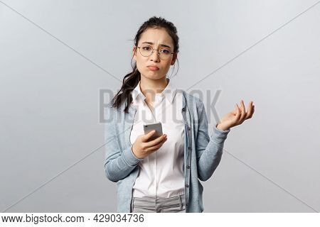 Office Lifestyle, Business And People Concept. Gloomy Indecisive And Puzzled Asian Woman Having Prob