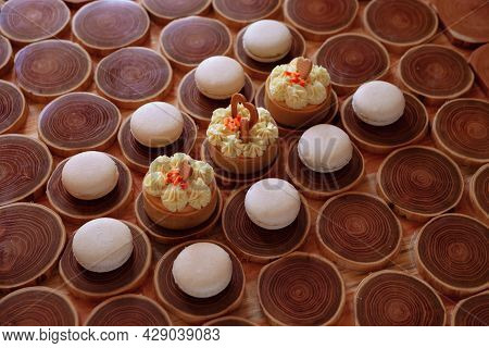 White Delicate Lowly Macaroons On A Wooden Background. The Pastel Tone Of The Cream Inside The Frenc