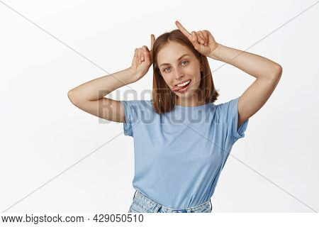Young Carefree Blond Woman Show Tongue, Bull Devil Horns Gesture On Head, Smiling Carefree, Having F
