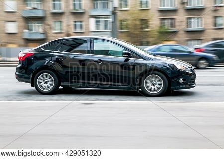 Black Ford Focus On The Road. Shiny Sedan Car Moving On The Street. Moscow, Russia - April 2021