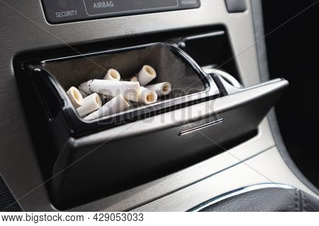 The Car Ashtray Is Filled With Smoked Cigarettes.