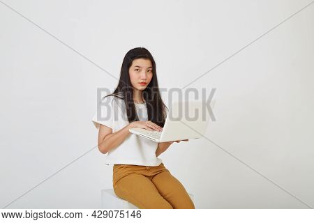 Woman With Laptop Computer Sitting Cross Legged And Looking