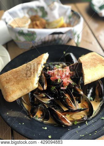 Close Up Of Freshly Cooked Mussles In A Plate With Ingredients