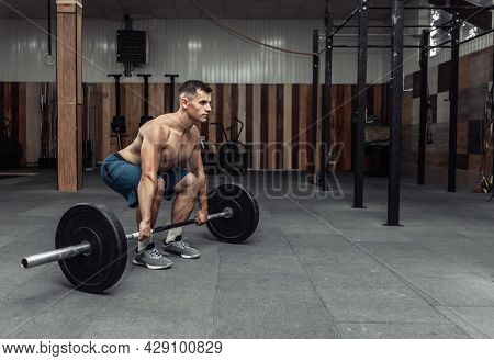 Muscular Bodybuilding Man Doing Deadlift Exercise With A Heavy Barbell In A Modern Health Club. Body