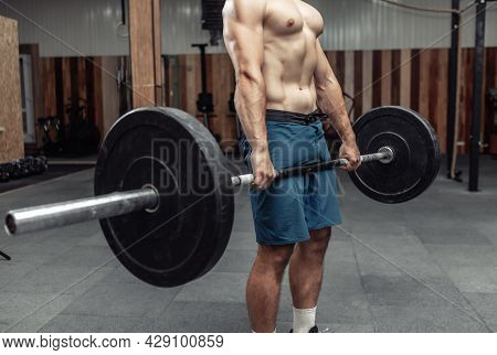 Muscular Bodybuilding Man Doing Deadlift Exercise With A Heavy Barbell In A Modern Health Club. Body