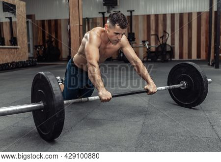 Athletic Muscular Man Exercising With Barbell In Modern Health Club. Bodybuilding And Fitness