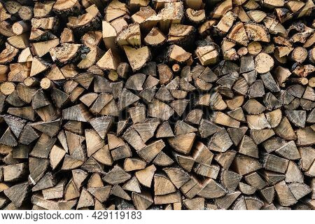 Background Of Hewed Smooth Wooden Logs. Cut Wood Texture. Pile Of Chopped Fire Wood Prepared For Win