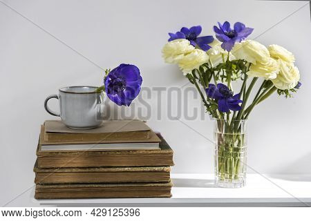 One Blue Anemone In A Cup In The Style Of The Seventies On The Table With Books As An Interior Decor