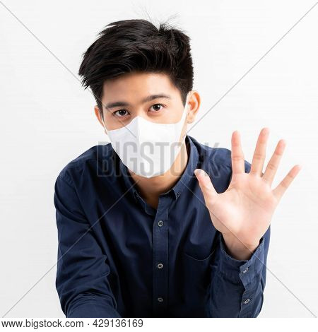 Stop Civid-19 , Asian Man Wearing Face Mask Show Stop Hands Gesture For Stop Corona Virus Outbreak ,