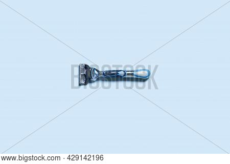 Mens Shaving Razor. A Multiple Use Shaving Razor On Blue Background. View From Above