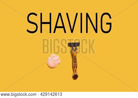Shaving Foam Gel And Razor On Orange Background. A Multiple Use Shaving Razor And Cream. View From A