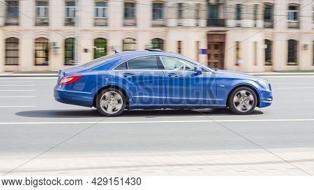 Mercedes Cls Class On The Road In Motion. Fast Speed Drive On City Road. Side View Of Moving Blue Ca