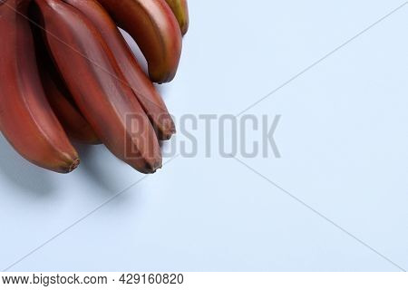 Tasty Red Baby Bananas On Light Background, Top View. Space For Text