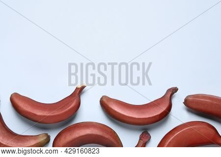 Tasty Red Baby Bananas On Light Blue Background, Flat Lay. Space For Text