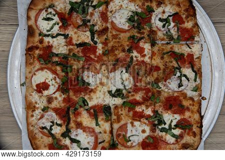 Overhead View Of Margaritta Pizza Loaded With Tomato Toppings And A Crispy Crust For A Full Family M
