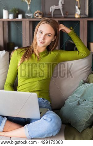 Portrait Of Young Attractive Cheerful Blonde Woman Freelancer In Jeans And Green Shirt Having Laptop