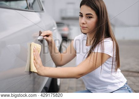 Front View Of Attractive Happy Joyful Female Driver Washing Her Car With Special Rag In Self-service