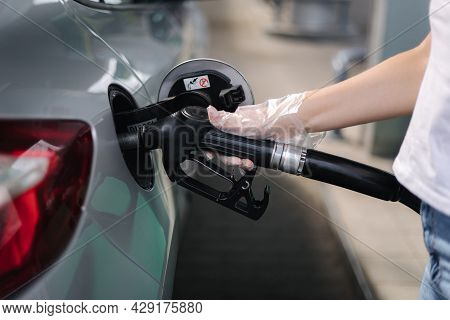 Woman Is Refueling At Gas Station. Female Hand Filling Benzine Gasoline Fuel In Car Using A Fuel Noz