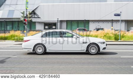 White Genesis G90 Facelift Cruising The Streets. Motion Image Of Premium Shiny Car Running On The Ci