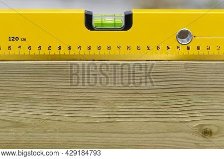 Yellow Spirit Level Levelling Horizontal On Wooden Board. Construction Worker Tool Measurement Tool 