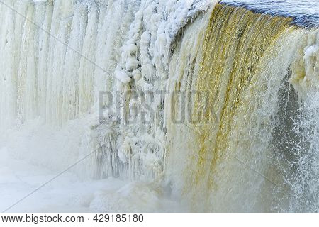 Frozen Beautiful Waterfall Jagala Under The Sunrise Lights In Winter, Reflection In River. Estonia.