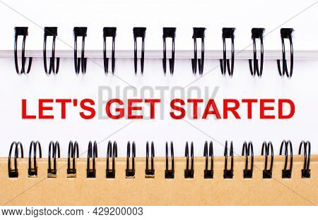 Text Let Is Get Started On White Paper Between White And Brown Spiral Notepads.