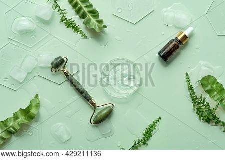 Moisturizer, Green Jade Face Roller With Exotic Fern Leaves. Ming Green Background With Moisturizer 