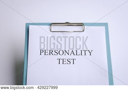Personality Test On Blue Clipboard, On White Tabletop.