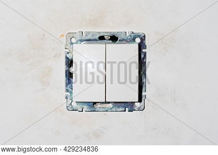 Two Dirty Light Switch Plastic Buttons Without Front Frame On Dirty White Gray Beige Raw Rough Wall.