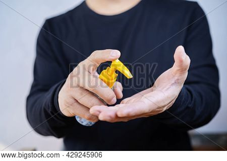 Antispetic Sanitizer In Hands. The Man Treats He Hands With An Antibacterial Agent. Disinfection Gel
