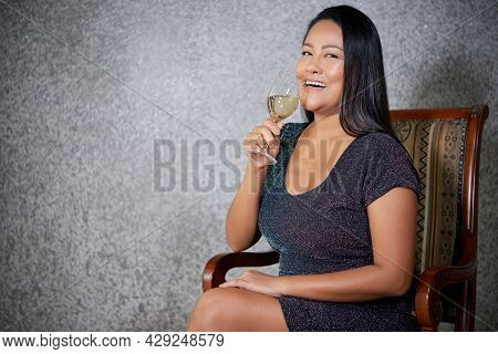 Portrait Of Happy Laughing Beautiful Woman Drinking Glass Of Champagne At Party And Looking At Camer