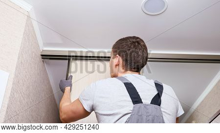 Employee Furniture Assembler In White T-shirt And Jumpsuit Checks Wooden Sliding Door Of Modern Ward