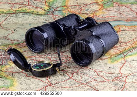 Binoculars And Trecking Compass On An Old Route Map