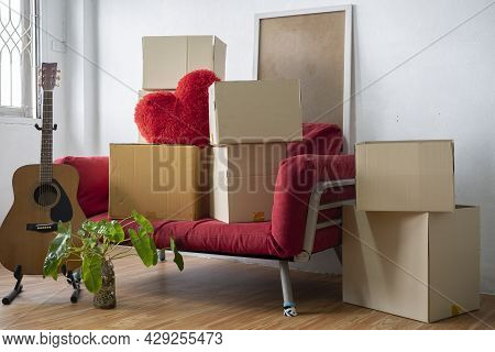 Moving Day Concept, Cardboard Carton Boxes Stack With Household Belongings In Modern House Living Ro