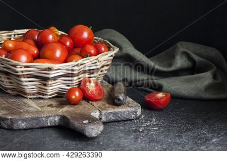 Fresh Red Tomatoes In Whicker Basket On Black Background