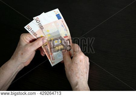 Euro Notes In Wrinkled Hands Of Elderly Woman. Concept Of Pension Payments, Savings At Retirement, A