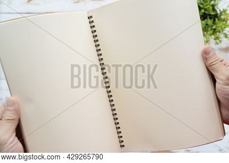 Gesture Of Male\'s Hand Holding A Book On Old Wooden Table, With Copy Space Ready For Text