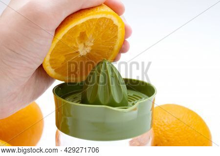 Hands Squeezing Fresh Orange Juice. Preparation Of Citrus Juice