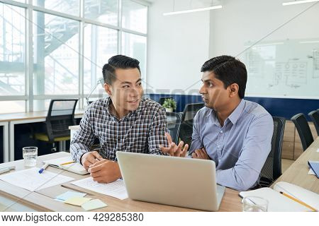 Multi-ethnic Team Of Ux Designers Discussing Interface Of New Monile Application They Are Working On