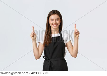Small Business, Employees And Coffee Shop Concept. Confient Pretty Barista In Black Apron Pointing F