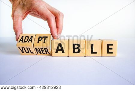 Vulnerable Or Adaptable Symbol. Businessman Turns Wooden Cubes And Changes The Word Vulnerable To Ad