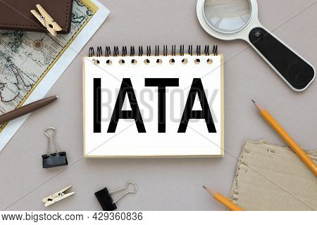 Iata. Text On Notepad Near Magnifier And Card With Notepad