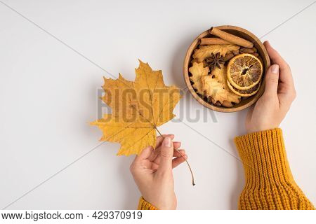 First Person Top View Photo Of Woman Hands In Yellow Sweater Holding Yellow Autumn Maple Leaf And Wo