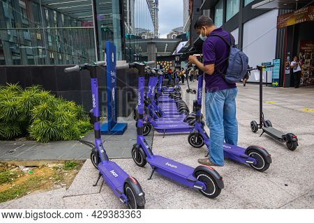 Kuala Lumpur, Malaysia - October 04, 2020: Asian Man Is Booking  Public Shared Electronic Scooter Fr