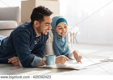 Creative Muslim Family Laying On Floor With Apartment Scheme