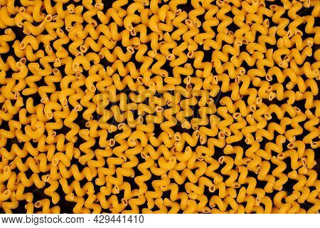 Italian Spiral Pasta On Black Background. Bunch Of Helical Amori Texture For Backdrop. Uncooked Cava