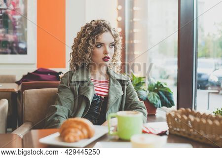 Young Anxious Woman Looking At Window In City Street Cafe